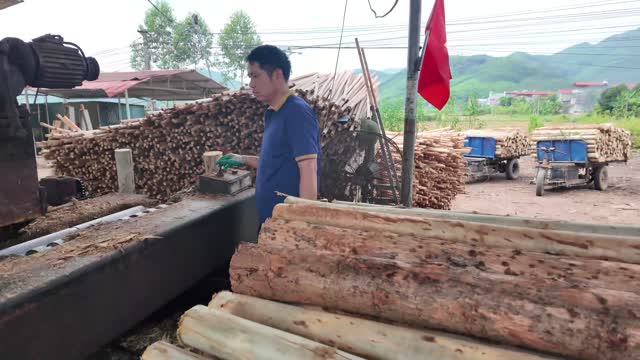 Man Debarking Logs At Machine