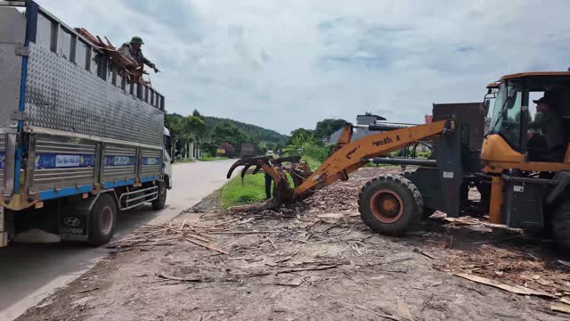 Loader Grabbing Wood Offcuts