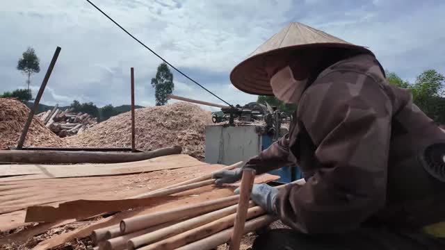 Worker Processing Wood Rods