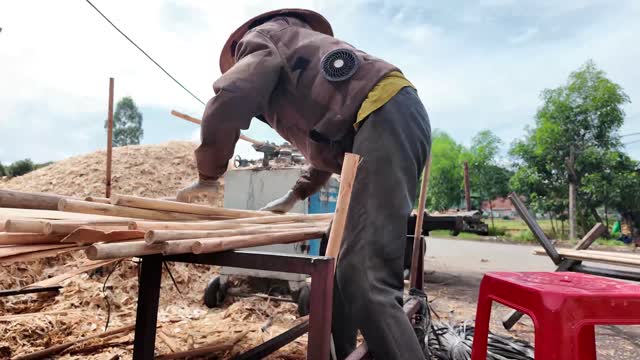 Worker Sorting Wooden Rods