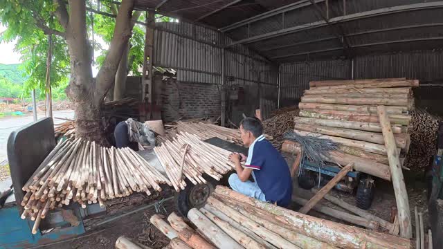 Worker Among Timber Poles