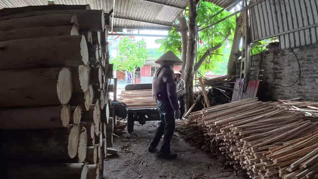 Workers Moving Timber In Shed