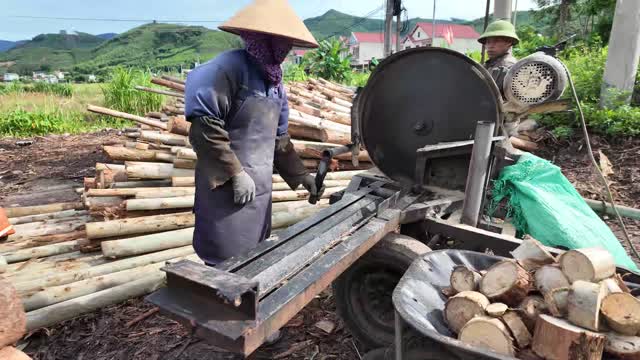 Two Workers Sawing Logs