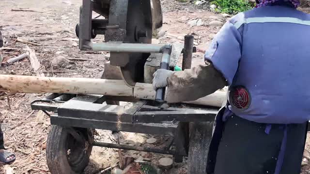 Hands Guiding Log Into Saw