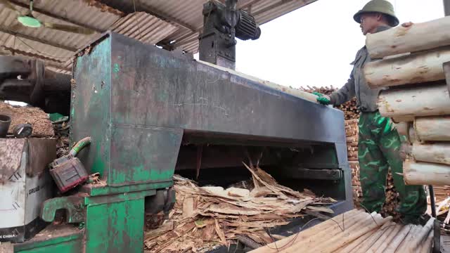 Worker At Log Rounding Machine