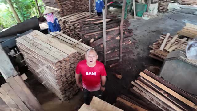 Man Standing Among Timber Stacks