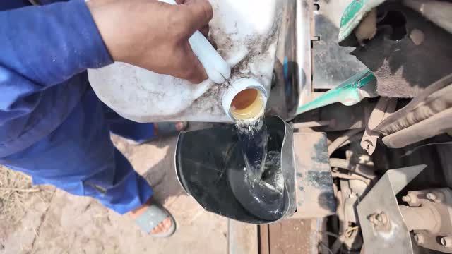 Pouring Oil Into Forklift