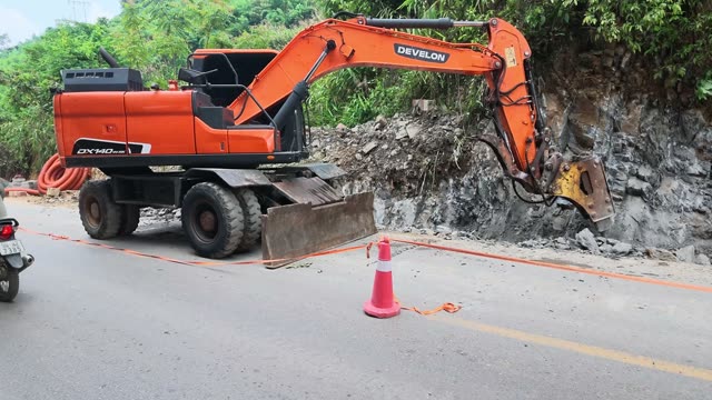Excavator Breaking Rock Wall