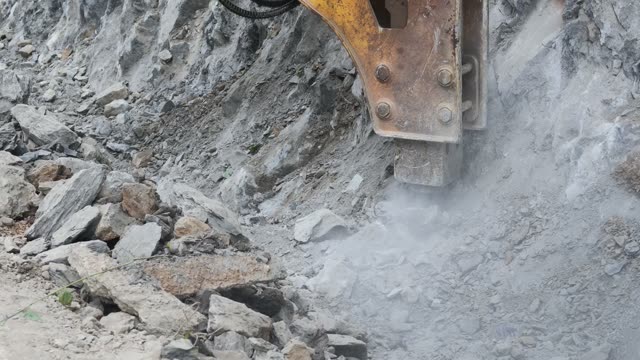 Hydraulic Breaker Smashing Rock