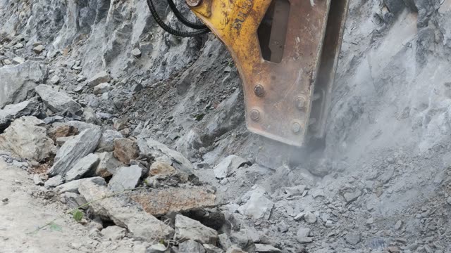 Hydraulic Breaker Smashing Rock