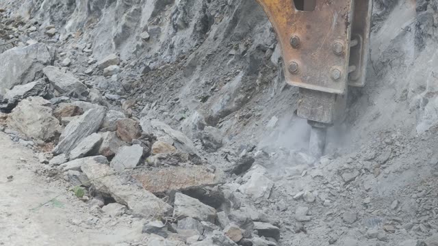 Hydraulic Breaker Smashing Rock
