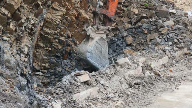Excavator Breaking Rock Wall