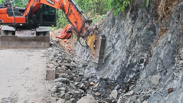 Excavator Breaking Rock Wall