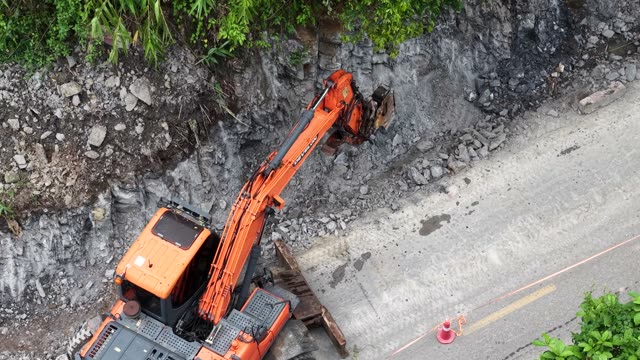 Excavator Clearing Roadside Rock