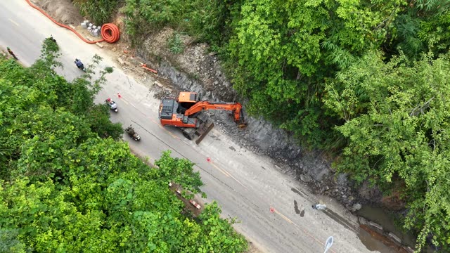 Motorbikes Passing Excavator On Road