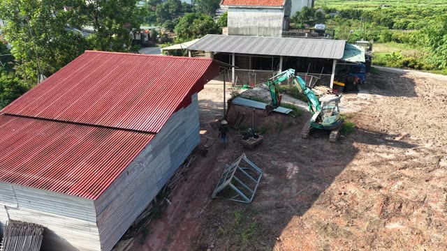 Excavator By Red Roof Shed