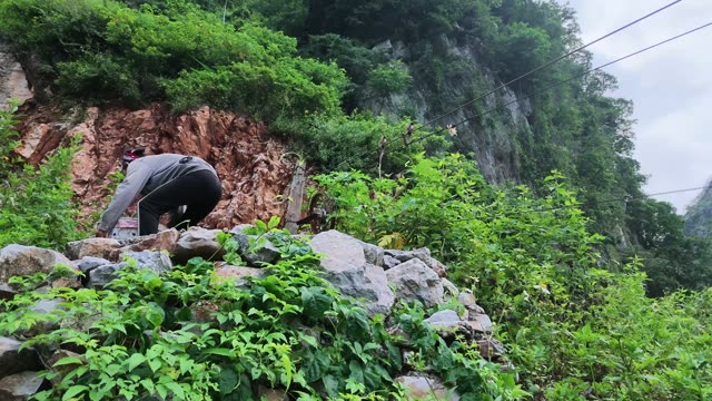 Man Working On Rocky Cliff Face