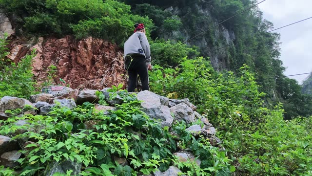 Person Overlooking Reddish Cliff Face