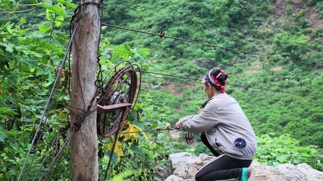 Woman Crouching By Cable Pulley