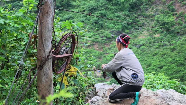 Woman Kneeling Beside Pulley Wheel