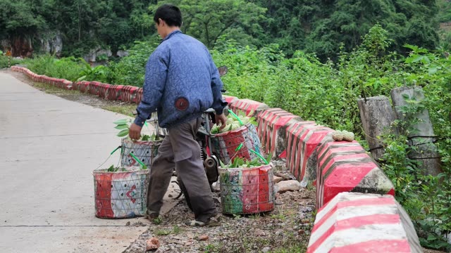 Man Carrying Baskets Along Road