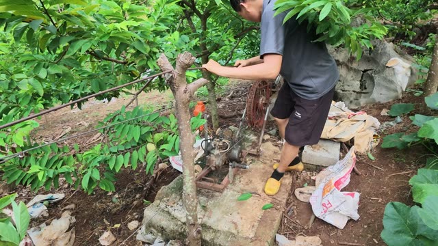 Man Repairing Pump By Rock