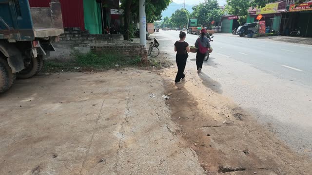 Two Women Walking Down Roadside Path