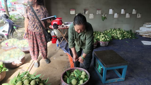 Woman Watching Basket Being Weighed