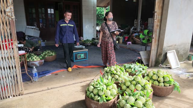People Walking By Fruit Baskets