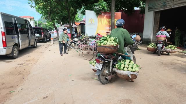 Man Pulling Cart Of Greens On Street