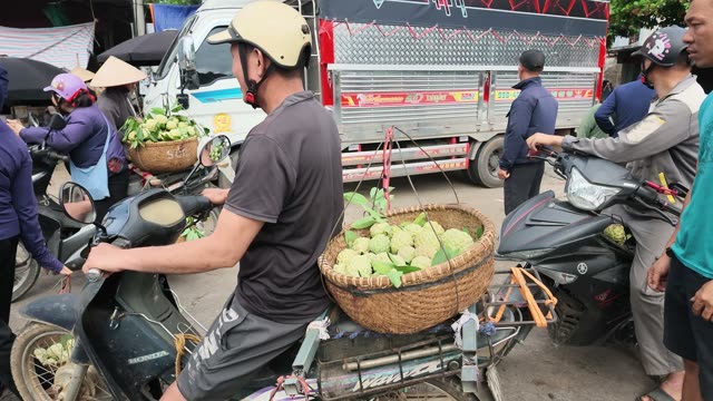 Man Riding Motorbike Through Market