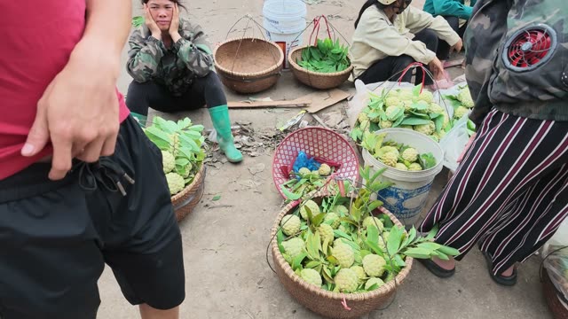 Woman Sitting By Fruit Baskets