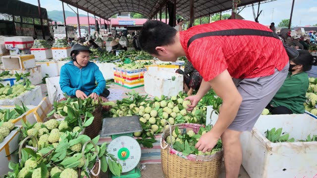 Man Weighing Basket At Market Stall