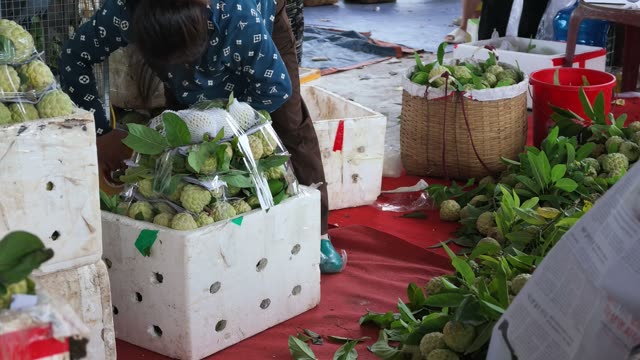 Man Sealing Box Of Custard Apples