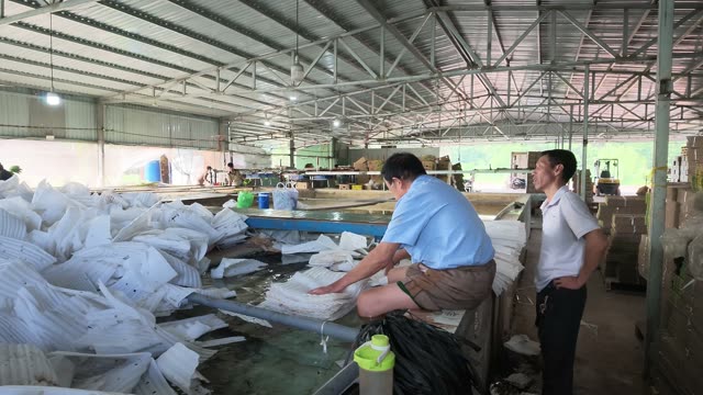Man Sitting By Foam Packing Pile
