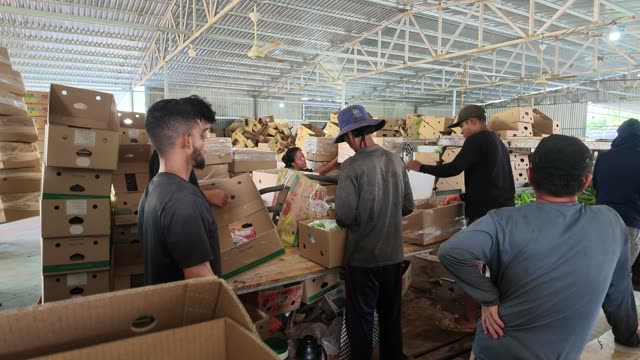 Workers Gathered Around Packing Table