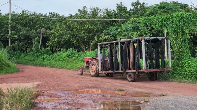 Tractor With Bag Trailer Driving Away