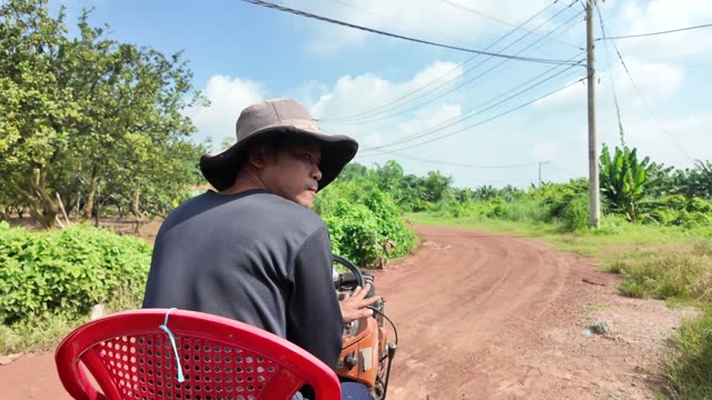 Worker Driving Tractor Through Countryside
