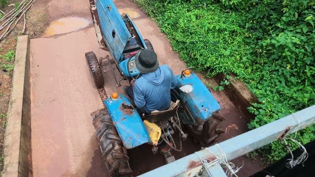 Worker Driving Tractor On Plantation Road