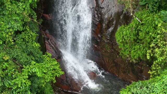 Waterfall Over Red Rocky Cliff