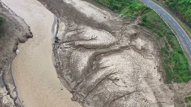 Dried Mud Flats Beside Muddy River