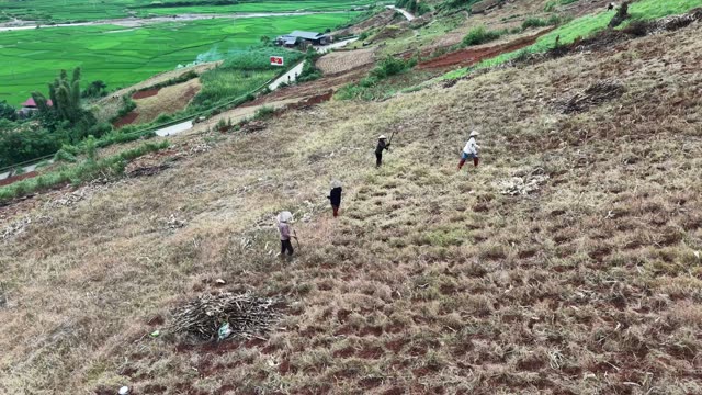 Farmers Tilling Hillside Above Village