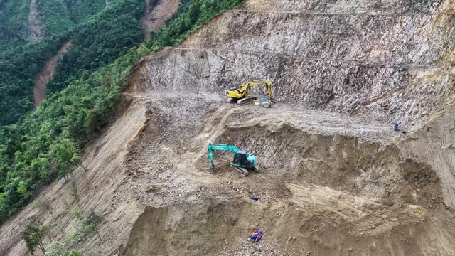 Excavator On Narrow Mountain Ridgeline