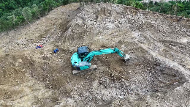 Two Excavators On Forested Hillside