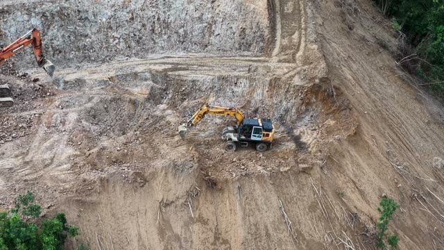 Excavators On Steep Cliff Face