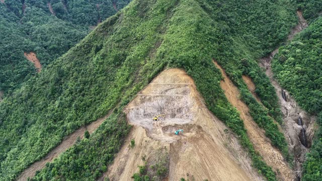 Excavator On Mountain Slope Above Valley