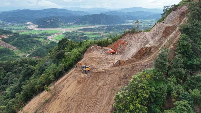 Excavator On Bare Mountain Slope