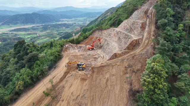 Excavator Above Terraced Farm Valley