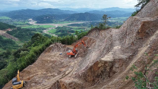 Excavator Clearing Mountain Debris Pile