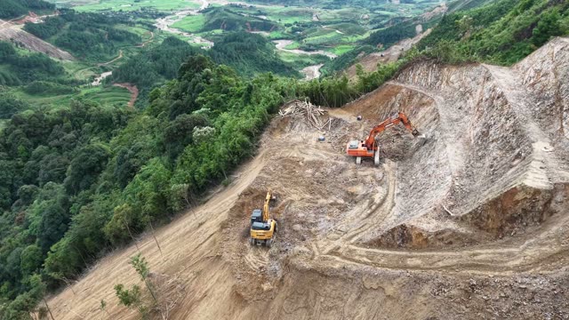 Excavator On Mountain Road Above Valley